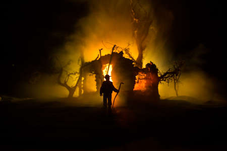 Old stone house burning uncontrollable in the night. A fire in a country house. Creative artwork...
