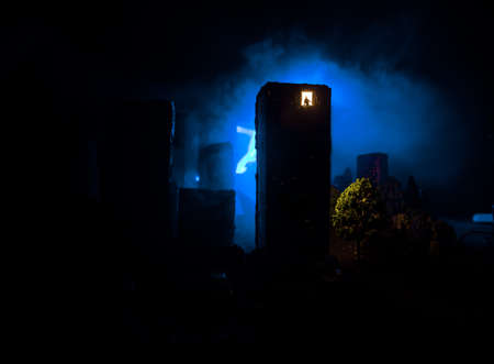 concept of loneliness, in the form of a silhouette of woman and man in a city window at night. Symbol of expectation, dreams and destinies. Creative decoration with City miniature. Selective focusの写真素材