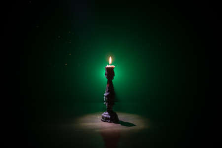 Single burning candle. Light of flame and flowing candle wax, dark background. Selective focus