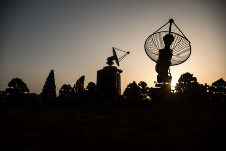 Space radar antenna on sunset. Silhouettes of satellite dishes or radio antennas against night sky. Creative artwork decoration. Selective focusの写真素材