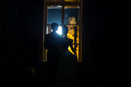 Beautiful view of a miniature city at night from window of dollhouse. Romantic couple at window....