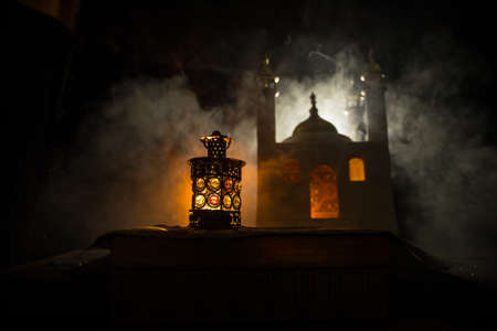 Ornamental Arabic lantern with burning candle glowing at night. Realistic mosque miniature on...