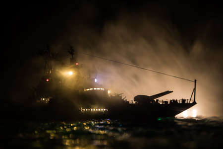 War concept. Night battle scene at sea. Dramatic toned clouds effect. Silhouette of the battle ship...