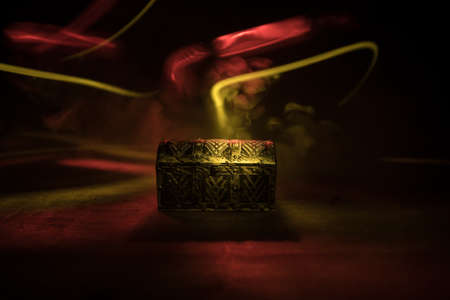 A dark wooden treasure chest with lid closed on wooden table. Selective focusの写真素材