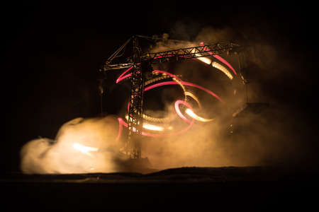 Abstract Industrial background with construction crane silhouette over amazing night sky with fog and backlight. Tower crane against the foggy sky at night. Industrial skyline. Selective focusの写真素材