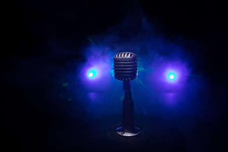 Retro style microphone on background with backlight. Vintage silver Microphone for sound, music,...