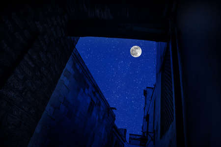 Old city streets at night. Full moon over the city at night, Baku Azerbaijan. Big full moon shining...