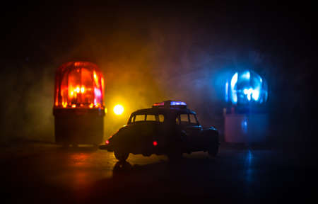 Police car chasing a car at night with fog background. 911 Emergency response police car speeding to scene of crime. Creative decoration. Selective focusの写真素材