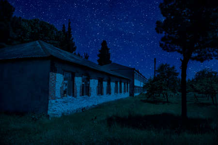Old house with a Ghost in the forest at misty night or Night scene with House under moon. Old mystic...