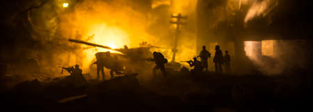 War Concept. Military silhouettes fighting scene on war fog sky background, World War Soldiers Silhouette Below Cloudy Skyline At night. Battle in ruined city. Selective focusの写真素材