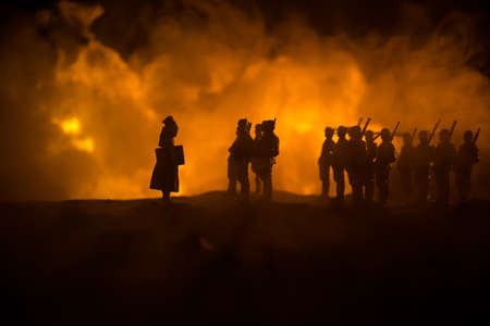 War Concept. Military silhouettes fighting scene on war fog sky background, World War Soldiers Silhouette Below Cloudy Skyline At night. German soldiers in ranks. Selective focusの写真素材