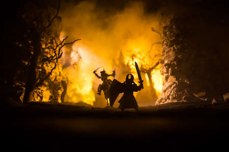Medieval battle scene with cavalry and infantry. Silhouettes of figures as separate objects, fight between warriors on dark toned foggy background with medieval castle. Selective focusの写真素材