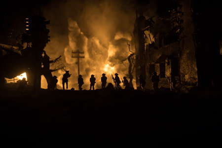 War Concept. Military silhouettes fighting scene on war fog sky background, World War Soldiers Silhouette Below Cloudy Skyline At night. Battle in ruined city. Selective focusの写真素材
