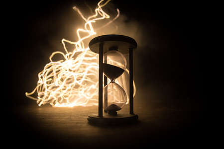 Time concept. Silhouette of Hourglass clock on dark toned background. Abstract concept with copy space. Selective focusの写真素材