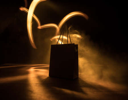 Shopping concept. Brown shopping bag with handles placed on dark desktop. Selective focusの写真素材
