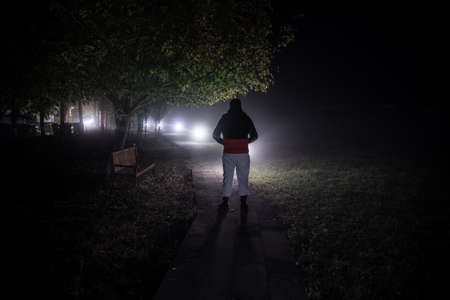 Silhouette of person standing in the dark forest with light. Horror halloween concept. strange...