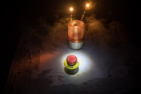 Emergency stop button, Disaster protection. Industrial concept. Red button on table in dark low key...