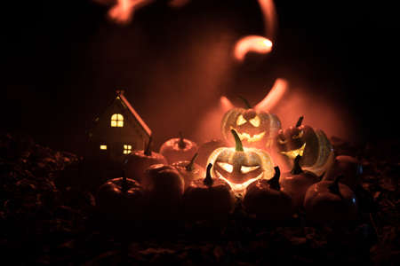 halloween jack-o-lantern on autumn leaves. Scary Halloween Pumpkin looking through the smoke....