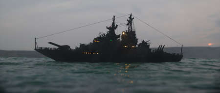 War concept. Night battle scene at sea. Dramatic toned clouds effect. Silhouette of the battle ship...