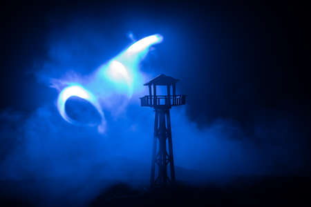 Creative artwork decoration. War concept. Silhouette of army watchtower at night. Selective focusの写真素材