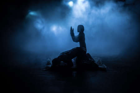 Silhouette of mosque building on toned foggy background. Ramadan Kareem background. Realistic mosque miniature with prayer silhouette. Selective focusの写真素材