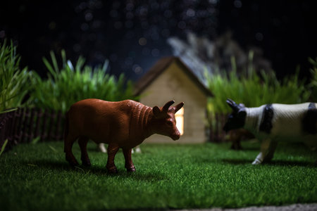 Herd of cows in the farm. Farm (village) life concept. Decorative toy figures at night. Selective...