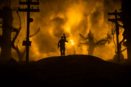 Silhouette soldier carrying little boy on his shoulder from fire. Rescue savior concept. Man moving...