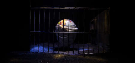 Corona virus lockdown creative concept. Planet earth trapped inside old prison. Creative artwork decoration. Selective focusの写真素材