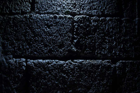 Stone wall dark background with light. Grunge style wall for backgroundの写真素材