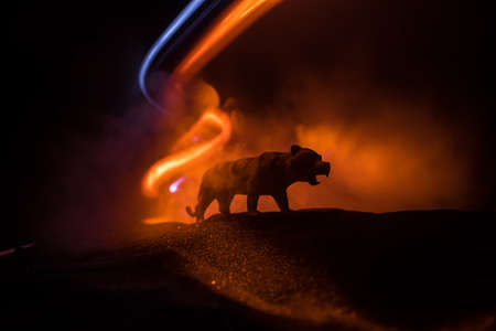 Silhouette of a tiger miniature standing at foggy night. Creative decoration with colorful backlight with fog. Selective focusの写真素材