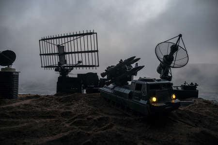 Creative artwork decoration. Silhouette of mobile air defense truck with radar antenna during...