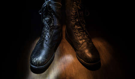 War concept. Old military shoe in a dark toned foggy background. Creative concept of military aggression. Selective focusの写真素材