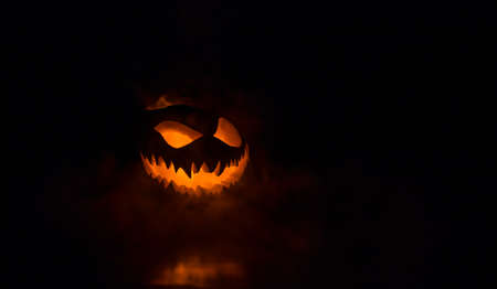 Halloween pumpkin smile and scary eyes for party night. Close up view of scary Halloween pumpkin...