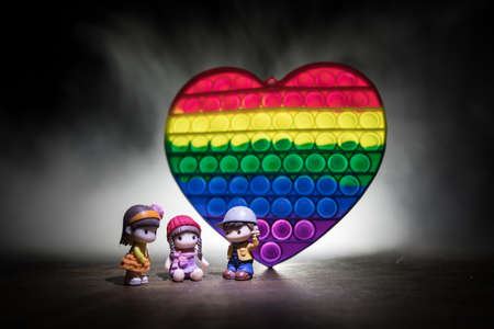 kids anti stress sensory or simple dimple fidget push toys on a dark background with light and fog....