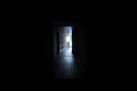 Dark corridor. Mystical interior of dark empty corridor, tunnel in an abandoned house. Dark mysterious corridor. The interior of an abandoned house, road to hell. An old abandoned buildingの写真素材