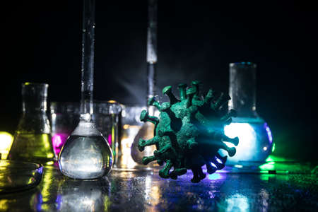 Corona virus Vaccine concept with syringe and green Corona virus novel miniature. Vaccine Concept of fight against coronavirus. Creative decoration with fog and backlight. Selective focusの写真素材