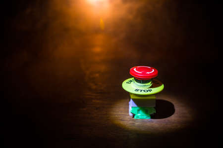 Emergency stop button, Disaster protection. Industrial concept. Red button on table in dark low key...