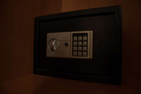 Small modern safe on shelf in dark. Small safe box close up in low key light. Selective focusの写真素材