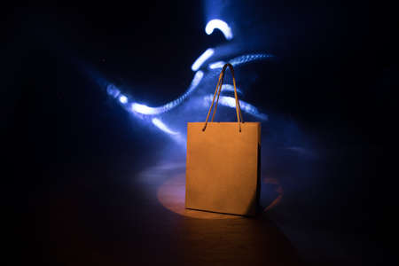 Shopping concept. Brown shopping bag with handles placed on dark desktop. Selective focusの写真素材