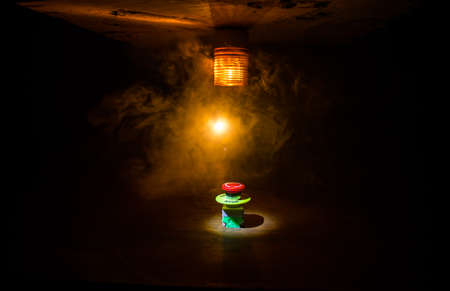 Emergency stop button, Disaster protection. Industrial concept. Red button on table in dark low key...