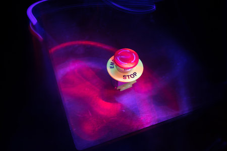 Emergency stop button, Disaster protection. Industrial concept. Red button on table in dark low key...