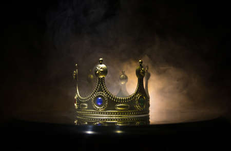 low key image of beautiful kings crown over metallic surface. vintage filtered. fantasy medieval period. Selective focus. Colorful backlightの写真素材