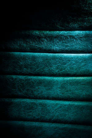 Dark natural luxury leather sofa textured background with faded light. Long exposure shotの写真素材