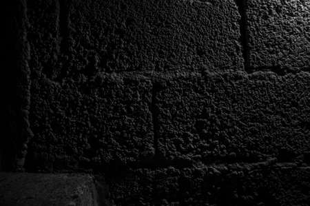 Stone wall dark background with light. Grunge style wall for backgroundの写真素材