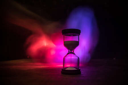 Time concept. Silhouette of Hourglass clock on dark toned background. Abstract concept with copy space. Selective focusの写真素材