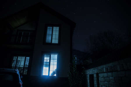 Old house with a Ghost in the forest at misty night or Night scene with House under moon. Old mystic building in dead tree forest.の写真素材
