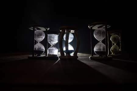 Time concept. Silhouette of Hourglass clock on dark toned background. Abstract concept with copy...
