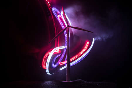 Electricity power in nature or clean energy concept. Wind Turbine producing alternative energy on hill at night. Creative decoration with small miniature. Selective focusの写真素材