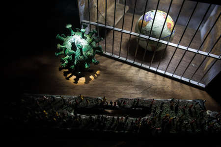 Corona virus lockdown creative concept. Crowd looking on Planet earth trapped inside old prison. Creative artwork decoration. Selective focusの写真素材