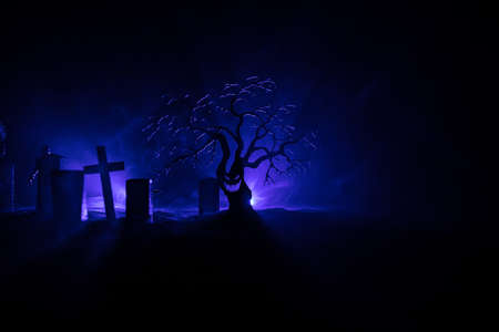 Scary view of zombies at cemetery dead tree, moon, church and spooky cloudy sky with fog, Horror...